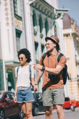 parmakla tarafından yakınındaki yürüyen kız kamera ile genç erkek turist  