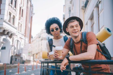 Kahve bardağı tutan ve uzak arıyor turistler çok kültürlü Çift