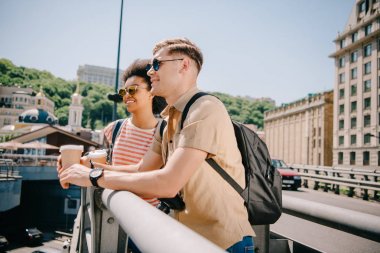 turist bakarak kahve fincanı ile çok kültürlü mutlu çift Köprüsü'nden görüntülemek 