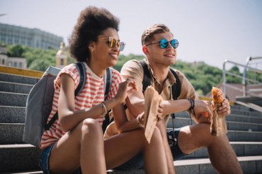 çok kültürlü şık çift güneş gözlüğü merdivenlerde kruvasan yemek 