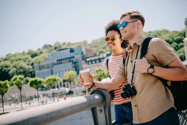 Smiling Interracial Couple Tourists Sunglasses Coffee Camera Looking View Bridge — Stock Photo, Image