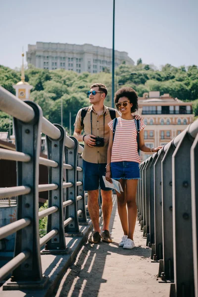 Multiethnic Couple Young Travelers Camera Backpacks Walking Bridge — Stock Photo, Image