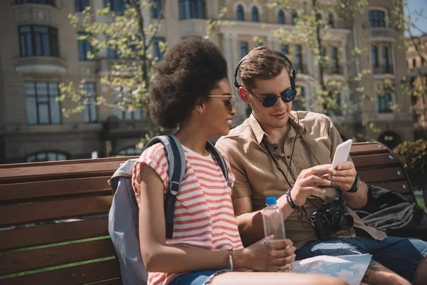 Young Man Camera Headphones Showing Smartphone African American Girlfriend Bench — Free Stock Photo