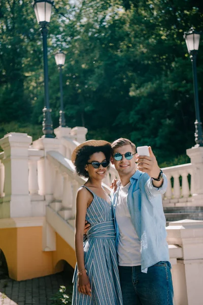 Jovem Casal Interracial Óculos Sol Tomando Selfie Smartphone Parque — Fotografia de Stock