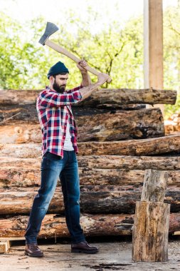  lumberjack in checkered shirt chopping log at sawmill  clipart