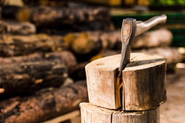closeup view of sticking axe in log at sawmill  clipart