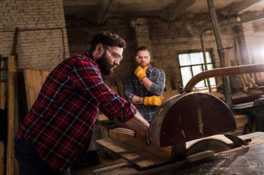 makine testere ve kereste fabrikası arkasında duran ortağı kullanarak Emanet googles marangoz