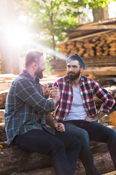 Bearded Lumberjacks Shaking Hands Each Other Sitting Logs Sawmill — Stock Photo, Image