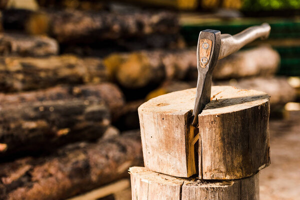 closeup view of sticking axe in log at sawmill 