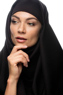 Güzel, genç Müslüman kadın tesettürlü, çenesine dokunuyor ve beyaz tenli bir şekilde yüzünü çeviriyor.