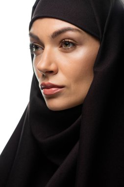 tesettürlü, çekici, genç Müslüman kadın beyaz tenli, yalnız bakışlarını kaçırıyor.