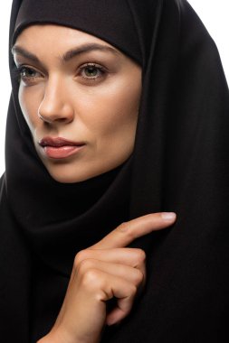 tesettürlü, çekici, genç Müslüman kadın beyaz tenli, yalnız bakışlarını kaçırıyor.