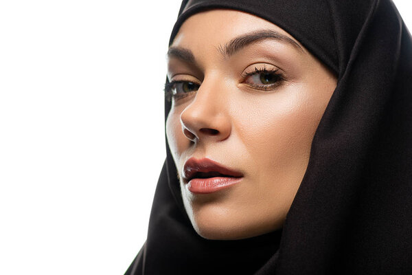 attractive young Muslim woman in hijab looking at camera isolated on white