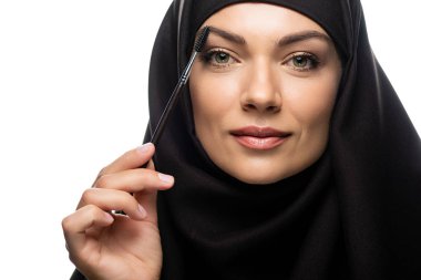 Beyaz kirpiklere rimel süren tesettürlü genç Müslüman kadın.