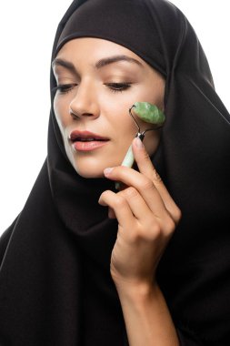 Genç Müslüman kadın tesettüre girmiş, yeşim taşı kullanıyor, beyaz üzerinde izole edilmiş.