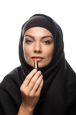 Bej rengi ruj süren tesettürlü genç Müslüman kadın beyaza izole edilmiş.