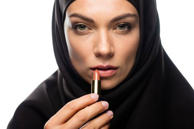 Bej rengi ruj süren tesettürlü genç Müslüman kadın beyaza izole edilmiş.