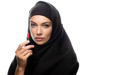 tesettürlü genç Müslüman kadın kırmızı ruj tutuyor beyaza izole edilmiş.
