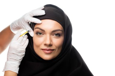 tesettürlü genç Müslüman kadın beyaza güzellik aşısı yaptırıyor.