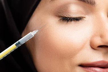 Kapalı gözlerle tesettürlü genç Müslüman kadının güzellik enjeksiyonuna yakından bakın.