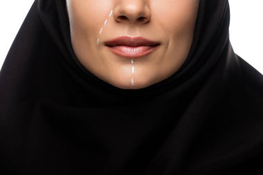 Beyaz üzerine izole edilmiş estetik ameliyat için yüzünde işaretler olan tesettürlü genç Müslüman kadın görüşü.