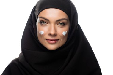 Beyaz tenli piliçlere kozmetik krem sürmüş genç Müslüman kadın.