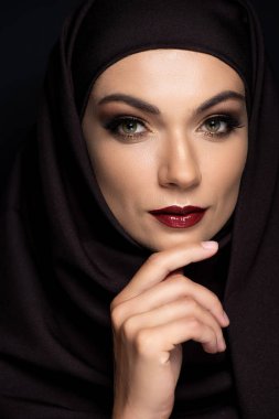 young Muslim woman in hijab with smoky eyes and red lips isolated on black clipart