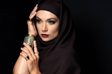 Altın yüzüklü ve siyah bilezik takan tesettürlü güzel Müslüman kadın.