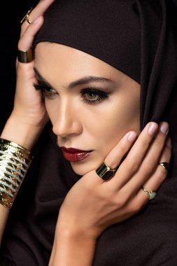 Altın yüzüklü ve siyah bilezik takan tesettürlü güzel Müslüman kadın.