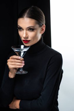 Güzel bir kadın, kırmızı dudaklı, beyaz ve siyah martini tutuyor.