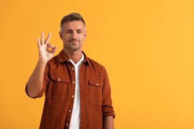 Neşeli adam turuncu üzerine izole edilmiş ok işareti gösteriyor. 