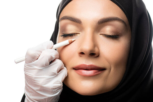 plastic surgeon marking young Muslim woman face for plastic surgery isolated on white