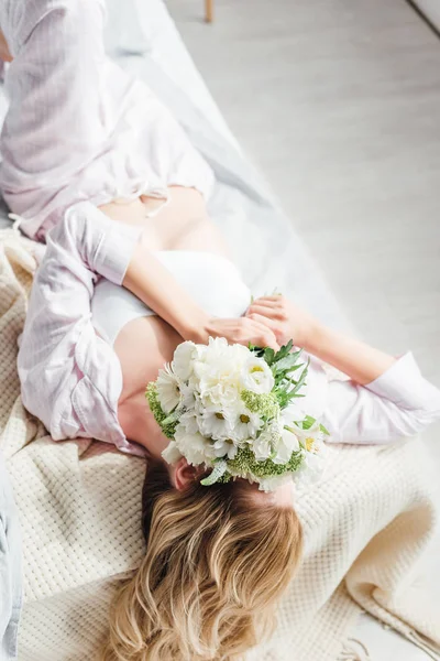 Chica Cubriendo Cara Con Flores Mientras Está Acostado Cama — Foto de Stock