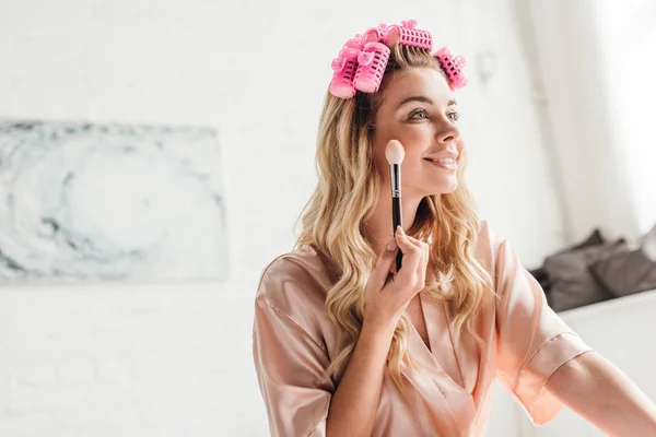 Cheerful Woman Pink Hair Curlers Holding Cosmetic Brush Face Bedroom — Stock Photo, Image