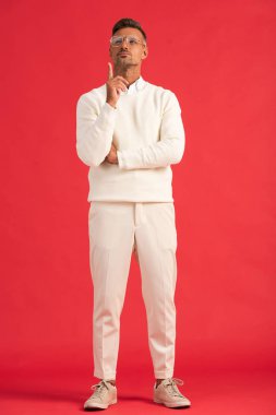 Gözlüklü yakışıklı adam, kırmızıyı işaret ederken yukarı bakıyor. 