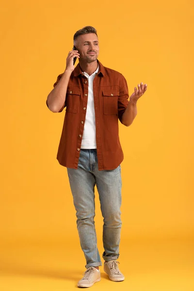 Happy Man Gesturing While Talking Smartphone Standing Orange — Stock Photo, Image