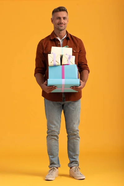 Bel Homme Souriant Tout Tenant Des Boîtes Cadeaux Sur Orange — Photo