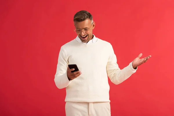 Gelukkig Man Bril Met Behulp Van Smartphone Gebaren Geïsoleerd Rood — Stockfoto