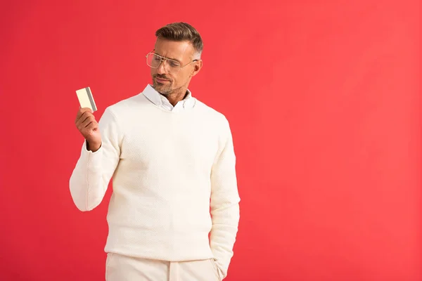 Stylowy Mężczyzna Okularach Trzymając Kartę Kredytową Odizolowany Czerwono — Zdjęcie stockowe