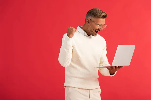 Opgewonden Stijlvolle Man Bril Houden Laptop Geïsoleerd Rood — Stockfoto