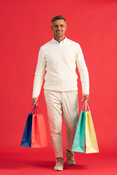 Hombre Alegre Gafas Sosteniendo Coloridas Bolsas Compras Rojo — Foto de Stock