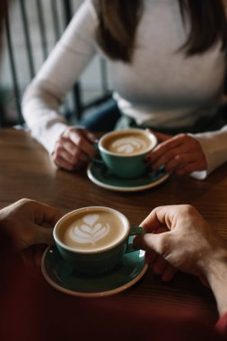 Kahve dükkanının balkonunda cappuccino içen çift manzarası.