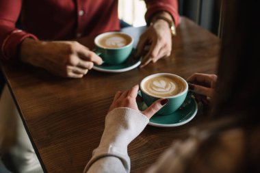 Kahve dükkanının balkonunda cappuccino içen çift manzarası.