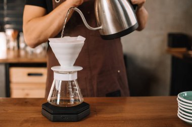 Barista 'nın filtrelenmiş kahve yaparken çekilmiş görüntüsü.