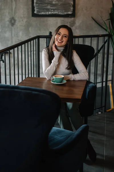 Sorrindo Jovem Mulher Sentada Mesa Madeira Com Cappuccino Varanda Café — Fotografia de Stock