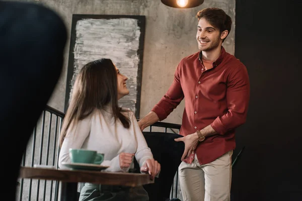 Glimlachende Vrouw Kijken Naar Man Duwen Stoel Balkon Coffeeshop — Stockfoto