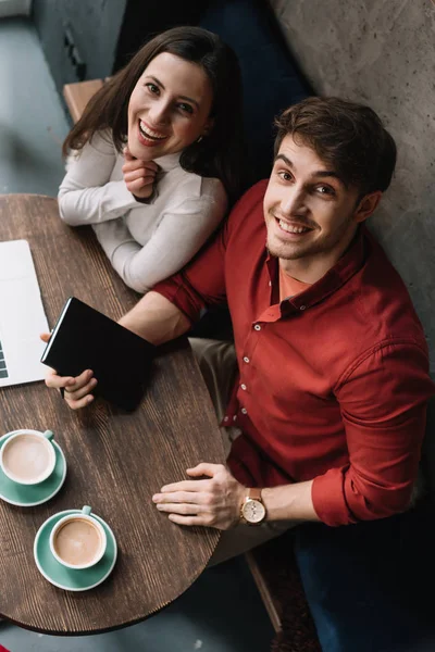 Kahve Dükkanında Dizüstü Bilgisayarla Çalışan Gülümseyen Genç Çiftin Genel Görünümü — Stok fotoğraf