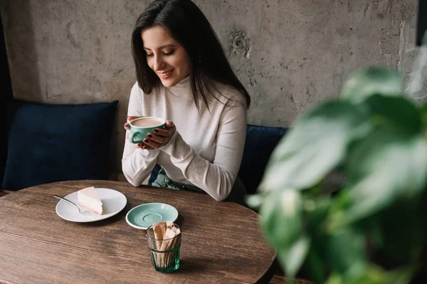 Selective Focus Green Plant Smiling Woman Drinking Coffee Cheesecake Cafe — Stock Photo, Image