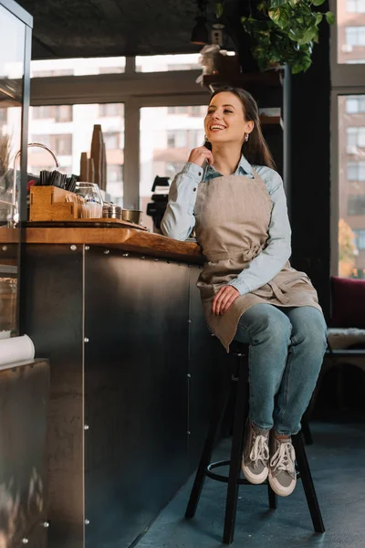 Önlüklü Gülümseyen Barmen Tezgahın Yanında Oturuyor — Stok fotoğraf