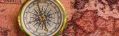 panoramic shot of golden compass near map 